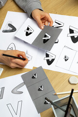 A graphic designer develops a logo for a brand. The illustrator draws sketches on paper. - 549043093