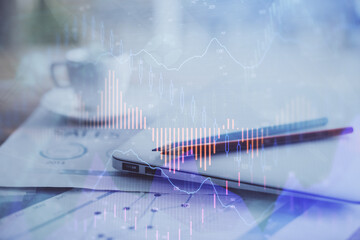 Forex graph hologram on table with computer background. Double exposure. Concept of financial markets.