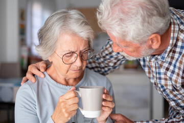 Old senior man comforting his depressed illness wife, unhappy elderly woman at home need medical help. Ourmindsmatter