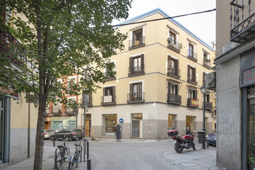 A crossroads of a street with vintage buildings with cobblestone lanes in the historic center of Madrid, Spain