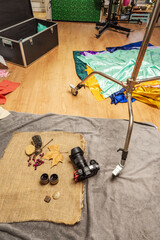 A camera on the ground next to photographic compositions and materials to prepare still lifes