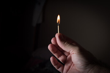 match in hand on dark background