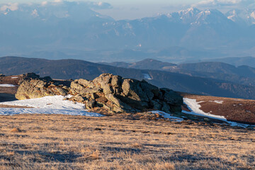 Scenic view of rock formation and Karawanks mountains at sunrise seen from alpine meadow at...