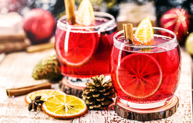 Christmas mulled red wine with spices and dried oranges on a rustic wooden table. Traditional hot drink for Christmas in the United States