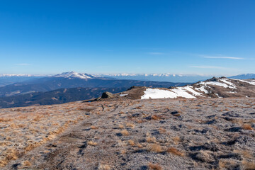 Hiking trail on frozen alpine meadow from Ladinger Spitz to Gertrusk, Saualpe, Lavanttal Alps, Carinthia, Austria, Europe. Morning hoar frost on cold early spring day. Trekking in the Austrian Alps