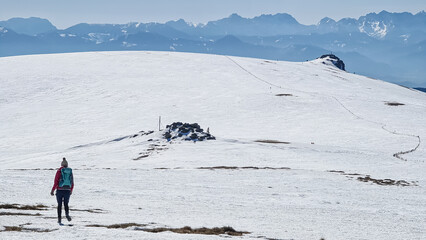 Woman hiking in snow covered landscape near Ladinger Spitz, Saualpe, Lavanttal Alps, Carinthia,...