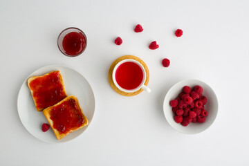 Cup of red tea and toasted bread with raspberry jam