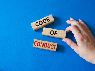 Code of conduct symbol. Wooden blocks with words Code of conduct. Beautiful blue background. Businessman hand. Business and Code of conduct concept. Copy space.