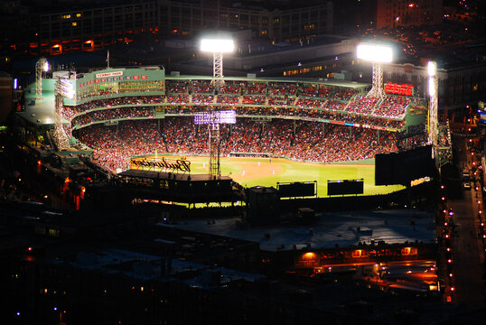 Fans crowd the historic Fenway Park, home of the Boston Red Sox, for a night game, seen in an aerial view