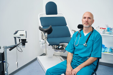 Doctor is in room for gynecological examination near the chair - obrazy, fototapety, plakaty