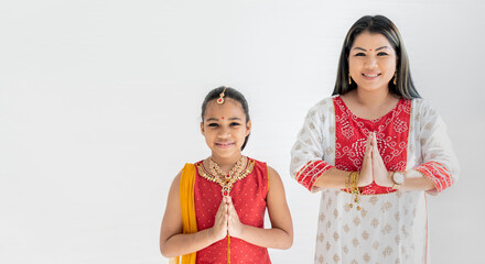Portrait images of mother and daughter wearing Indian national dress, with white background. to...