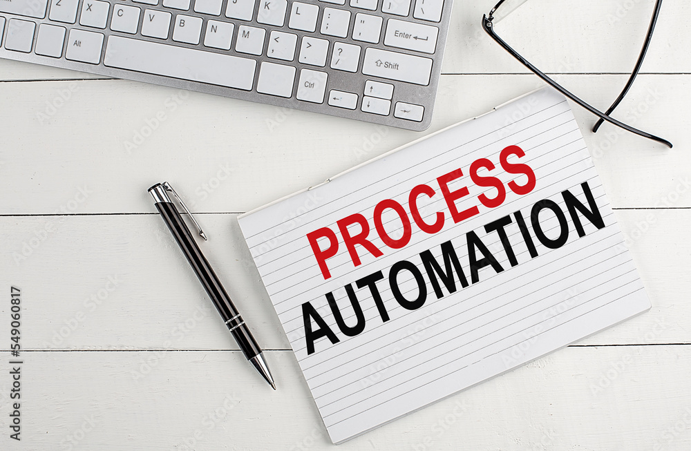Poster process automation text on notebook with keyboard , pen glasses on white wooden background