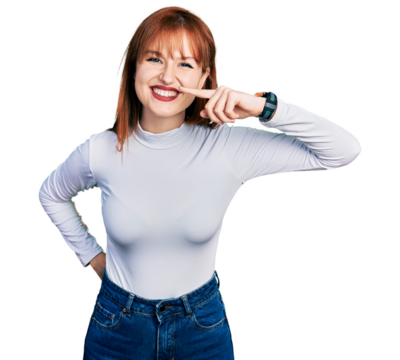 Redhead young woman wearing casual turtleneck sweater pointing with hand finger to face and nose, smiling cheerful. beauty concept