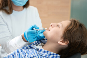 Obraz na płótnie Canvas Teenager boy in dental clinic ona tooth color selection procedure