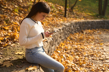 Frowning young woman is holding a phone in her hands