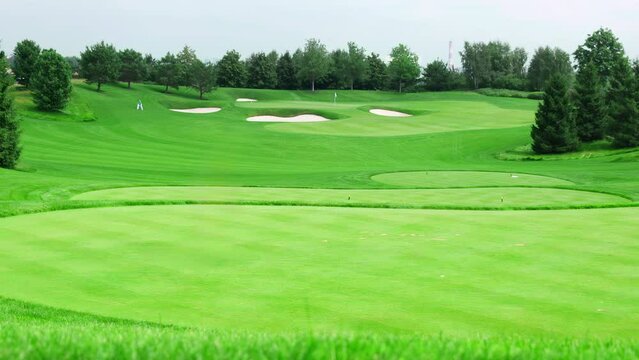 An empty green course with golf holes on a clear summer day 
