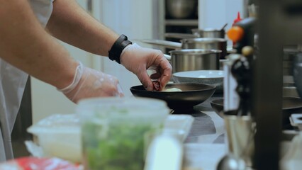 The chef is preparing a sweet dish. Sweet dessert from the chef. A dish of vegetables and fruits. Commercial kitchen. Cooking a signature dessert from the chef