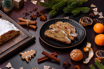 Fototapeta premium Christmas pie stollen with marzipan, berries and nuts on a dark concrete background