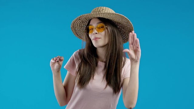 Irritated woman showing bla-bla-bla gesture with hands, rolling eyes on blue background. Empty promises, blah concept. Lier.