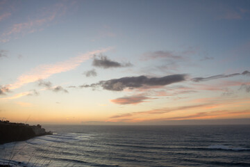 beautiful seascape at sunset. Silhouette of a fishing village. The sun sets on the horizon behind the sea. Pink and golden clouds in blue sky. Bajamar, Tenerife, Canary Islands.  