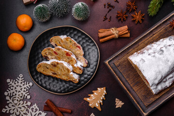 Christmas pie stollen with marzipan, berries and nuts on a dark concrete background