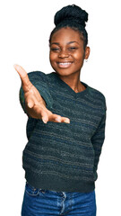 Young african american woman wearing casual clothes smiling friendly offering handshake as greeting and welcoming. successful business.