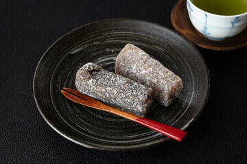 黒い背景のくるみ餅とお茶