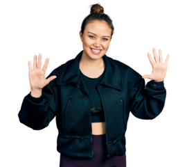 Young hispanic girl wearing sportswear showing and pointing up with fingers number ten while smiling confident and happy.