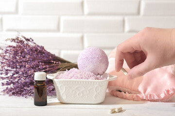 Fototapeta na wymiar hand holding Melatonin capsules. Relaxing bath salt and bath bomb with lavender oil. Lavender as calming and soothing ingredient for good sleep. insomnia support. 