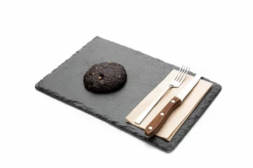 Foto op Canvas Closeup of a chocolate cookie on a black tray with silverware on the side on a white background © Galip Kürkcü/Wirestock Creators