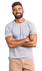 Young hispanic man wearing casual clothes happy face smiling with crossed arms looking at the camera. positive person.