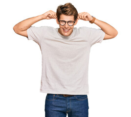 Handsome caucasian man wearing casual clothes and glasses smiling pulling ears with fingers, funny gesture. audition problem