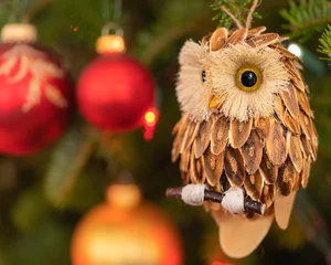 Poster Rustic wooden owl ornament hanging in a Christmas tree. © V. J. Matthew