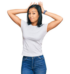 Beautiful hispanic woman wearing casual white tshirt doing bunny ears gesture with hands palms looking cynical and skeptical. easter rabbit concept.