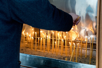 Moldovita, Romania, 2021-12-29. A group of believers light candles in the Moldovita Monastery in...