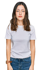 Young beautiful woman wearing casual white t shirt relaxed with serious expression on face. simple and natural looking at the camera.