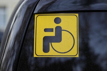 Closeup of a disabled sign attached on a car