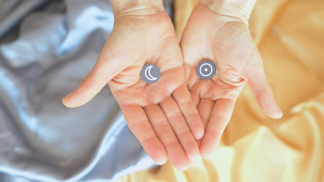Primer plano de dos manos de mujer cerradas que se abren y muestran s&iacute;mbolos del Sol y de la Luna. Concepto astrolog&iacute;a, d&iacute;a, noche, personalidad e inconsciente, eclipses, luz y oscuridad.   