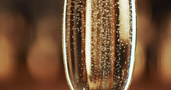 Bubbles, gold and closeup of glass with champagne for party, celebration and event with nobody. Wedding, birthday or restaurant with sparkling wine or alcohol for luxury, congratulations and cheers