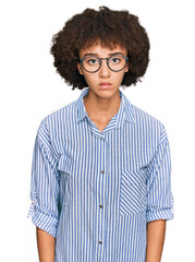 Fototapeta na wymiar Young hispanic girl wearing business shirt and glasses with serious expression on face. simple and natural looking at the camera.