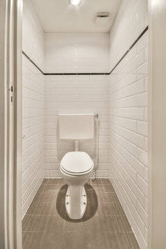 Bathroom with white ceramic tiled walls and toilet bowl