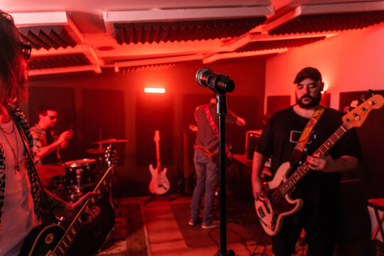 Music band performing song in studio with neon red illumination