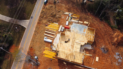 Wooden house under construction with framing of beams and rafters, joints, trusses in residential...