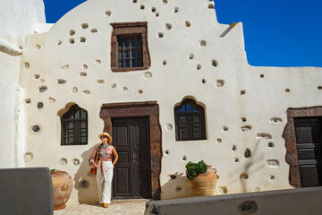 Woman stands at the entrance to the church of Santorini Island
