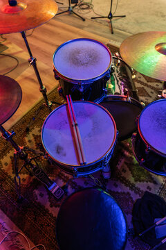 Drums with drumsticks on carpet in studio