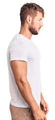 Young caucasian man wearing casual white tshirt looking to side, relax profile pose with natural face with confident smile.