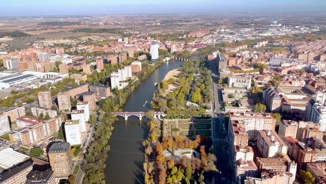 Aerial perspective of Valladolid city. Situated in Spain, in Castilla y Leon Province. View of River Pisuerga and La Rosaleda Park. Drone pull back. Beautiful panorama of whole city. 
