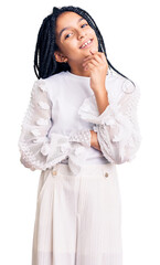 Cute african american girl wearing casual white tshirt looking confident at the camera with smile with crossed arms and hand raised on chin. thinking positive.