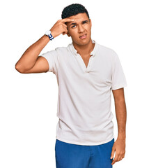 Fototapeta premium Young arab man wearing casual clothes pointing unhappy to pimple on forehead, ugly infection of blackhead. acne and skin problem