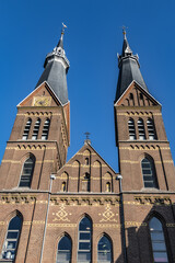 Obraz premium Neo-Gothic Post Horn Church (Posthoornkerk, 1863) with three slender towers on bustling Haarlemmerstraat - one of most important surviving XIX century churches. Sunset. Amsterdam, the Netherlands.